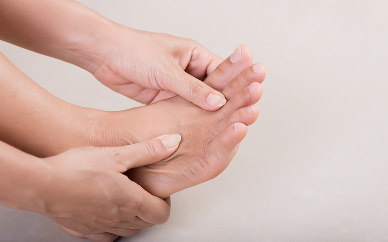 Person checking their foot for bunion pain and deformities.