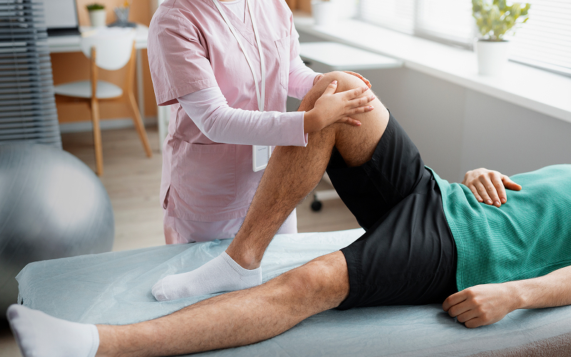 Specialist Orthopaedic doctor examining patient's painful knee joint.