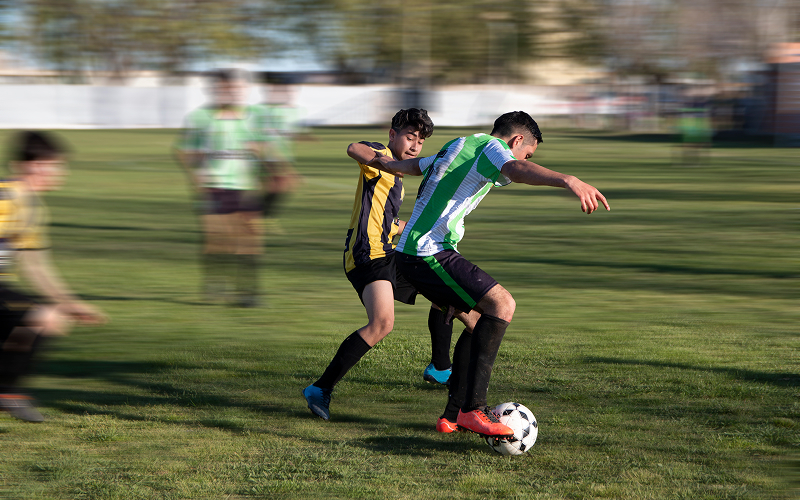 Soccer players colliding causing potential meniscus or MCL tear injury.